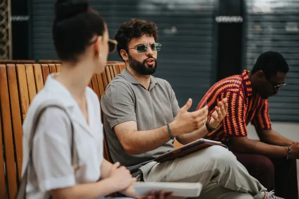 stock image Businesspeople sharing ideas and discussing work in an outdoor setting, creating a collaborative atmosphere.