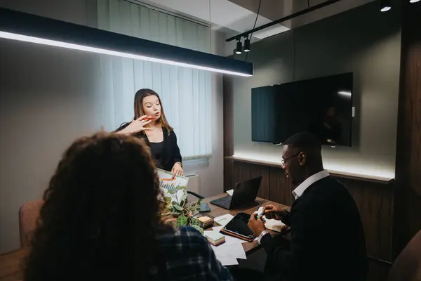 stock image A diverse group of coworkers engaged in discussing growth data at a well-lit office meeting, enhancing team collaboration and productivity.