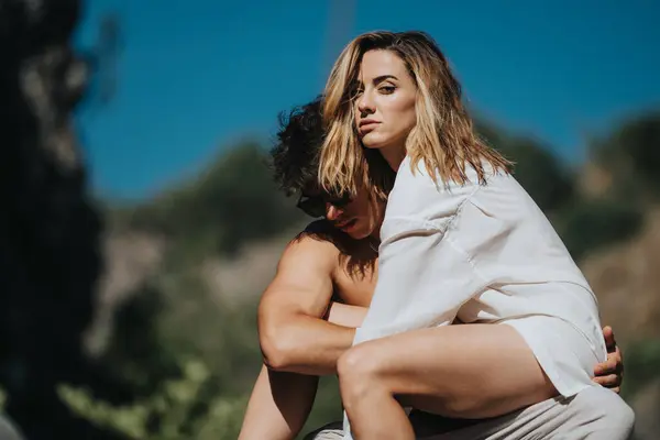 stock image Young couple embracing closely outdoors on a sunny day, expressing affection and intimacy.