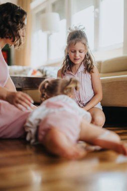 Mother enjoying playful moments with her two daughters at home. Happy family bonding and spending quality time together indoors in a warm, cozy setting. clipart