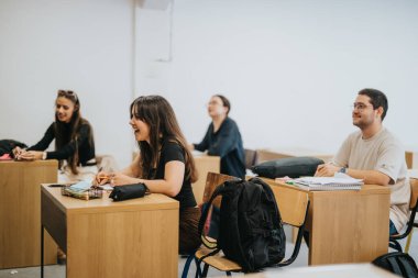 A group of attentive high school students actively participating in a classroom setting. They appear focused while listening and taking notes during the lesson, highlighting a collaborative learning clipart