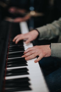 A musicians hands skillfully playing a piano during a band rehearsal, showcasing musical talent. clipart