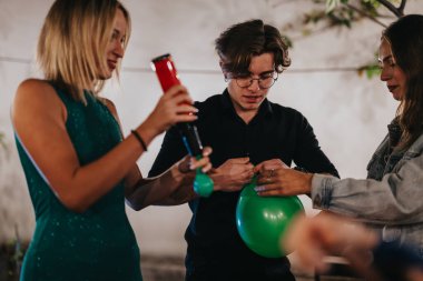 A group of young friends prepares decorations during a cozy celebration at home, featuring balloons and creative teamwork. clipart