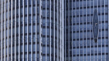 Saati olan yüksek bir binanın güçlendirilmiş beton cephesi..