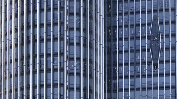 Saati olan yüksek bir binanın güçlendirilmiş beton cephesi..