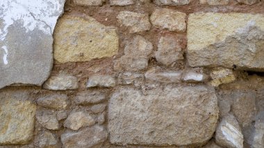 Taşlardan ve tuğlalardan oluşan eski bir duvar. Geçmişe uygun..