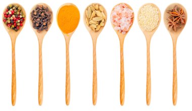 Beyaz arka planda farklı baharatlı ahşap kaşık. Kaşığın görüntüsü tek bir şekilde. Manzaralı. Tahta kaşıkta yedi farklı baharat..