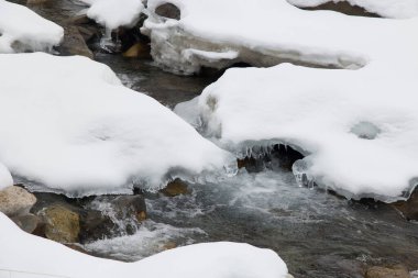 View of alpine river with snow in Valle Aurina, Northern Italy, Europe