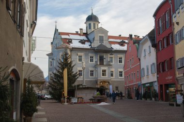 BRUNICO, ITALY - DECEMBER 29, 2022: View of the big square of Brunico city during winter with colored palace in Alto Adige, Italy