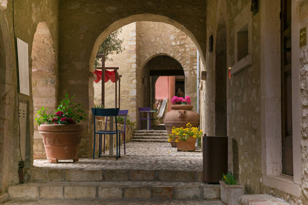 CASTELLO DI POSTIGNANO, ITALY - APRIL 30, 2023: Archs in the old center of Postignano with colored chairs in Umbria region, Italy
