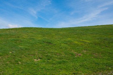 İtalya 'da bahar mevsiminde yeşil tepelerin ve mavi gökyüzünün manzarası