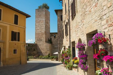 SPELLO, İTALYA - 9 Mayıs 2023: İtalya 'nın Umbria bölgesindeki ortaçağ çiçekleri kasabası Spello' nun merkezindeki kule manzarası