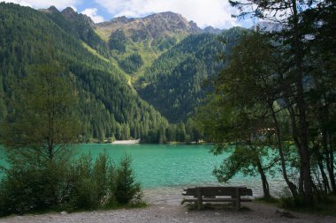 A romantic bench on the famous Anterselva lake in Alto Adige, Italy clipart