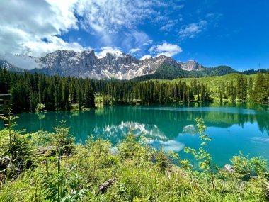 İtalyan Dolomitlerinde güneşli Carezza Gölü 'nün panoramik manzarası