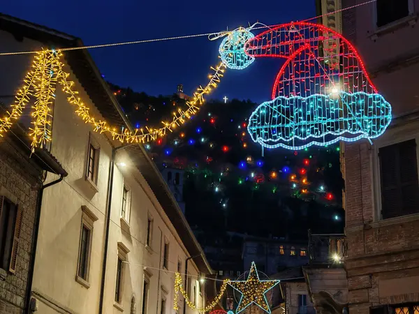 Aralık, Umbria bölgesinde yılbaşı süsleriyle eski Gubbio caddesi manzarası, İtalya