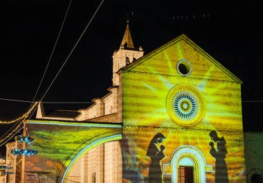 Noel zamanı Assisi, Umbria bölgesinde aydınlatılan ve süslenen Santa Chiara Bazilikası 'nın güzel manzarası