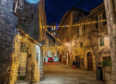 ASSISI, İtalya - 10 ARALIK 2024: Assisi, Umbria Bölgesi, İtalya 'nın merkezinde eski bir ara sokağı gece görüşü