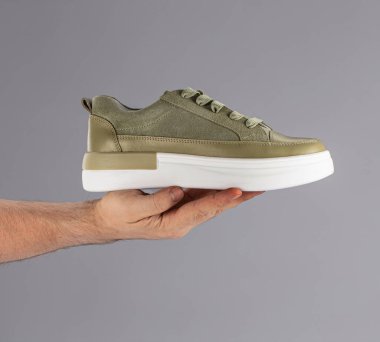 Modern sokak ayakkabıları gri arka planda taş üstüne taş gibi duruyor.