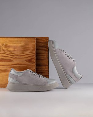 Modern sokak ayakkabıları gri arka planda taş üstüne taş gibi duruyor.