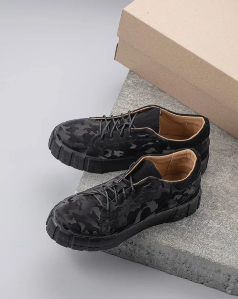 现代街上的鞋子是用石头做的 背景是灰色的 — 图库照片