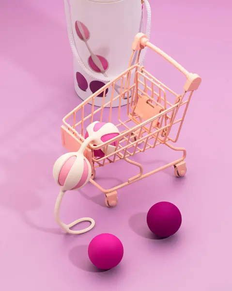 活泼的硅胶阴道球放置在粉色背景的迷你推车上 现代女性私密购物的有趣概念 成人性玩具 免版税图库图片