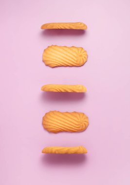 Yumuşak ve çıtır çıtır Danimarka usulü kurabiyeler pembe arka plana dizilmiş. Popüler tatlı ikramının basit zarif sunumu