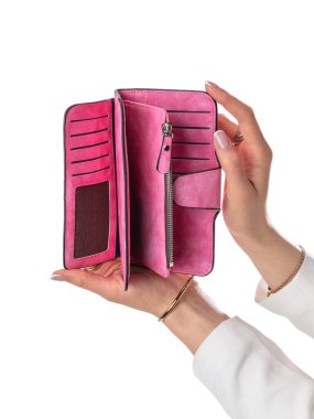 Kadın elleri, kart oynamak için birden fazla yuvası olan pembe deri cüzdanı, para için fermuar bölmeleri ve beyaz arka plana karşı bozuk paraları tutuyor. Şık ve uygun kadın aksesuarı