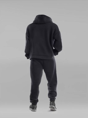 Bir figür siyah kapüşonlu ve eşofman altı giymiş, kameraya dönük. Ayarlar, tek renk biçimini geliştirerek, basit bir gri arkaplan içerir..