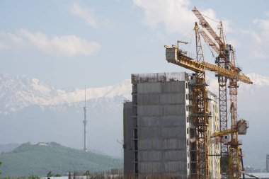 Almaty, Kazakistan - 04.26.2022: Bir yol kavşağı yakınında yüksek katlı bir konut inşaatı.