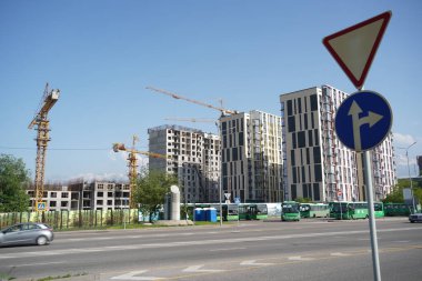 Almaty, Kazakistan - 04.26.2022: Bir yol kavşağı yakınında yüksek katlı bir konut inşaatı.