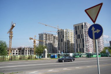 Almaty, Kazakistan - 04.26.2022: Bir yol kavşağı yakınında yüksek katlı bir konut inşaatı.