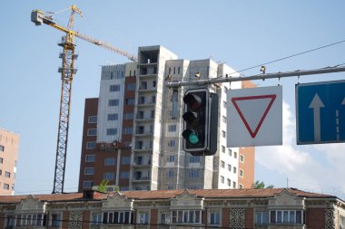 Almaty, Kazakistan - 04.26.2022: İnşaat halindeki bir sitenin arka planında trafik ışığı.