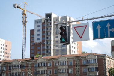 Almaty, Kazakistan - 04.26.2022: İnşaat halindeki bir sitenin arka planında trafik ışığı.