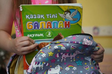 Almaty, Kazakhstan - 05.18.2022 : A child puts school textbooks in his backpack at home.