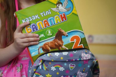 Almaty, Kazakhstan - 05.18.2022 : A child puts school textbooks in his backpack at home.