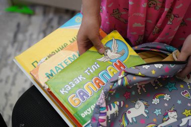 Almaty, Kazakhstan - 05.18.2022 : A child puts school textbooks in his backpack at home.