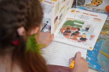 Almaty, Kazakhstan - 05.18.2022 : The girl is doing school homework in her room.