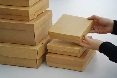A woman holds cardboard boxes for parcels and delivery