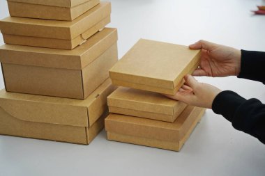 A woman holds cardboard boxes for parcels and delivery