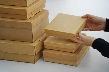 A woman holds cardboard boxes for parcels and delivery