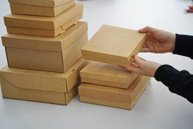 A woman holds cardboard boxes for parcels and delivery