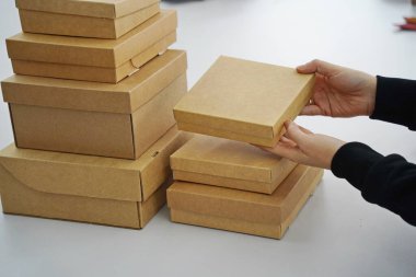 A woman holds cardboard boxes for parcels and delivery