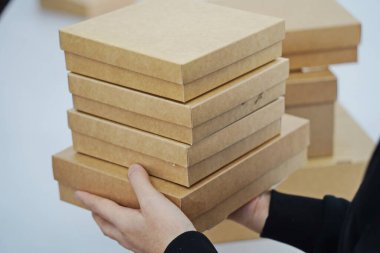 A woman holds cardboard boxes for parcels and delivery