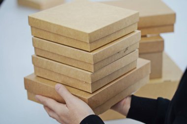 A woman holds cardboard boxes for parcels and delivery