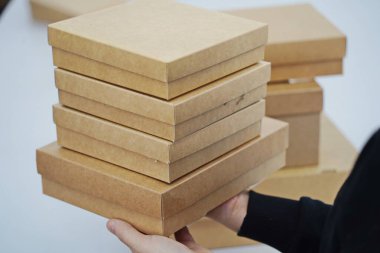 A woman holds cardboard boxes for parcels and delivery