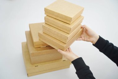 A woman holds cardboard boxes for parcels and delivery