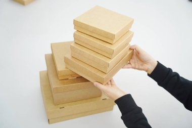 A woman holds cardboard boxes for parcels and delivery