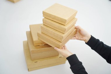 A woman holds cardboard boxes for parcels and delivery