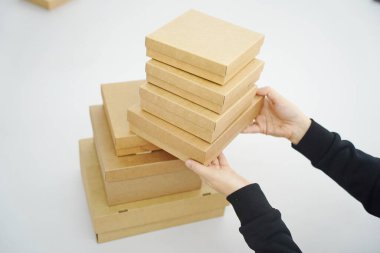 A woman holds cardboard boxes for parcels and delivery