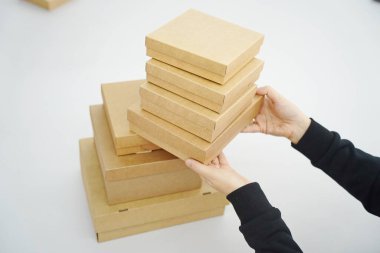 A woman holds cardboard boxes for parcels and delivery
